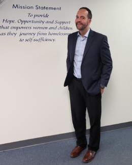 Home of the Sparrow Executive Director<br />
Matt Kostecki standing in front of wall painted with the organization's Mission Statement.