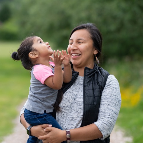 Image of woman carrying a young girl